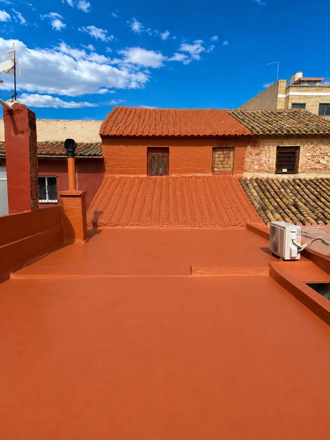 Terraza impermeabilizada en tono terracota con vistas a los tejados