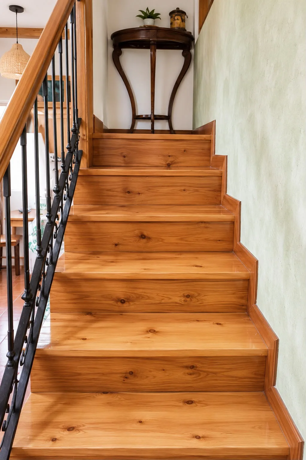 Escalera interior de madera barnizada con barandilla de forja
