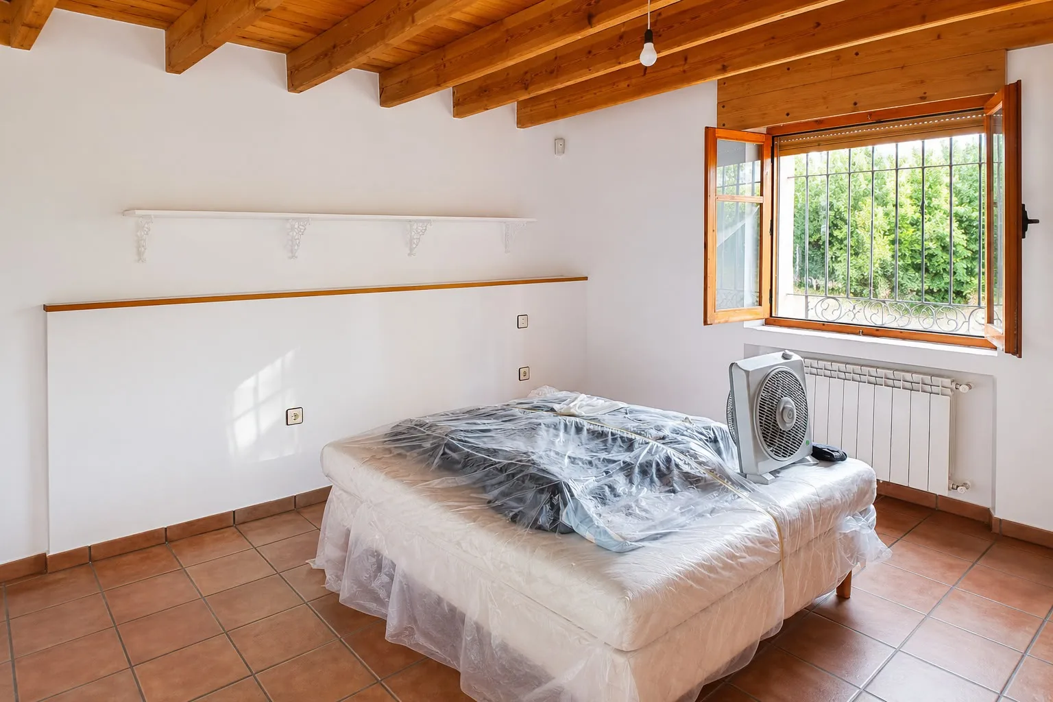 Dormitorio protegido con plásticos durante el trabajo de alisado de paredes Dormitorio protegido con plásticos durante el trabajo de alisado de paredes